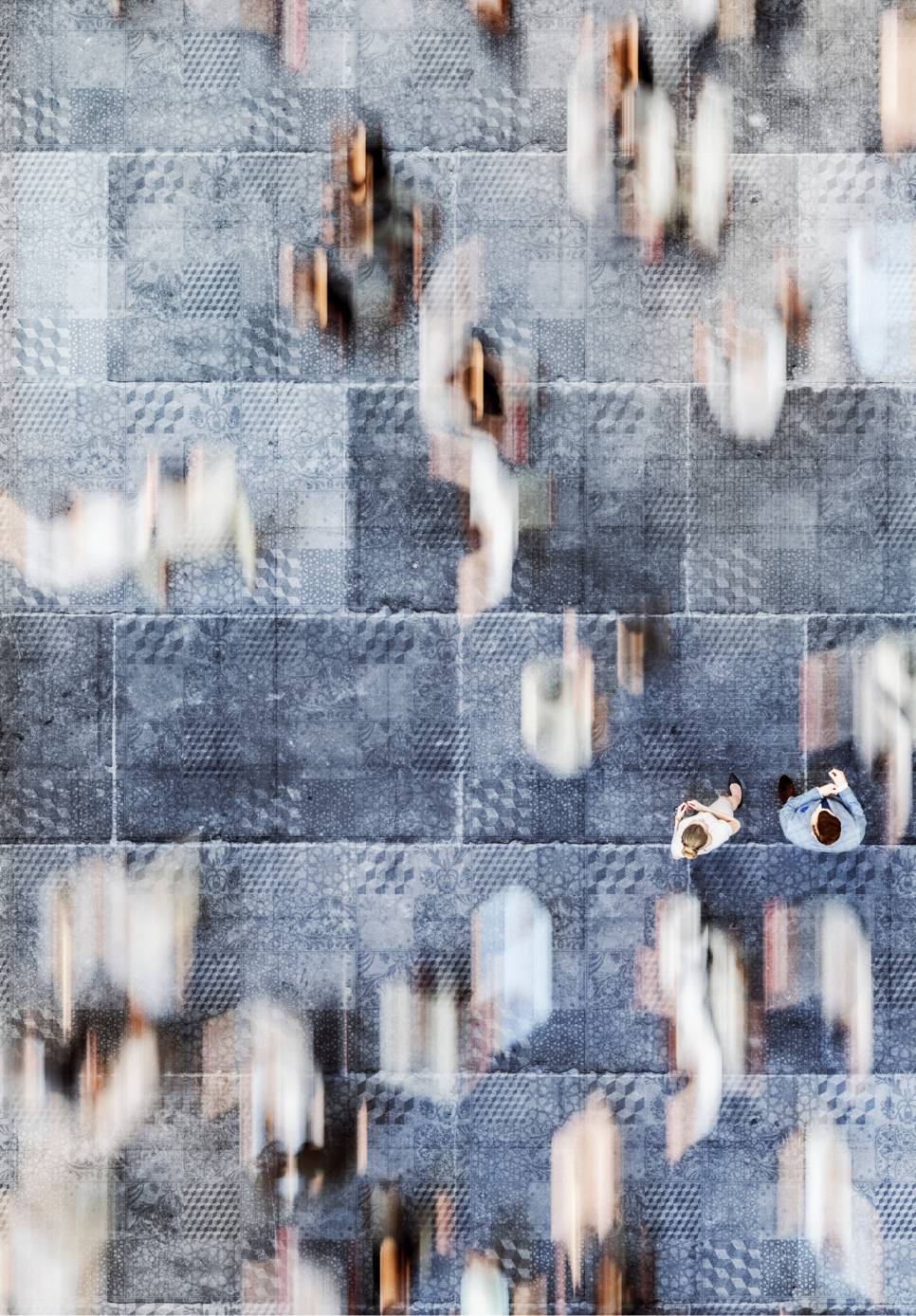 Distorted top-down image of people walking on the pavement.