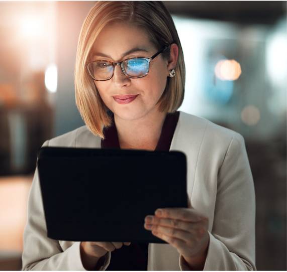 Woman at work, actively conversing, with laptop on right displaying content.